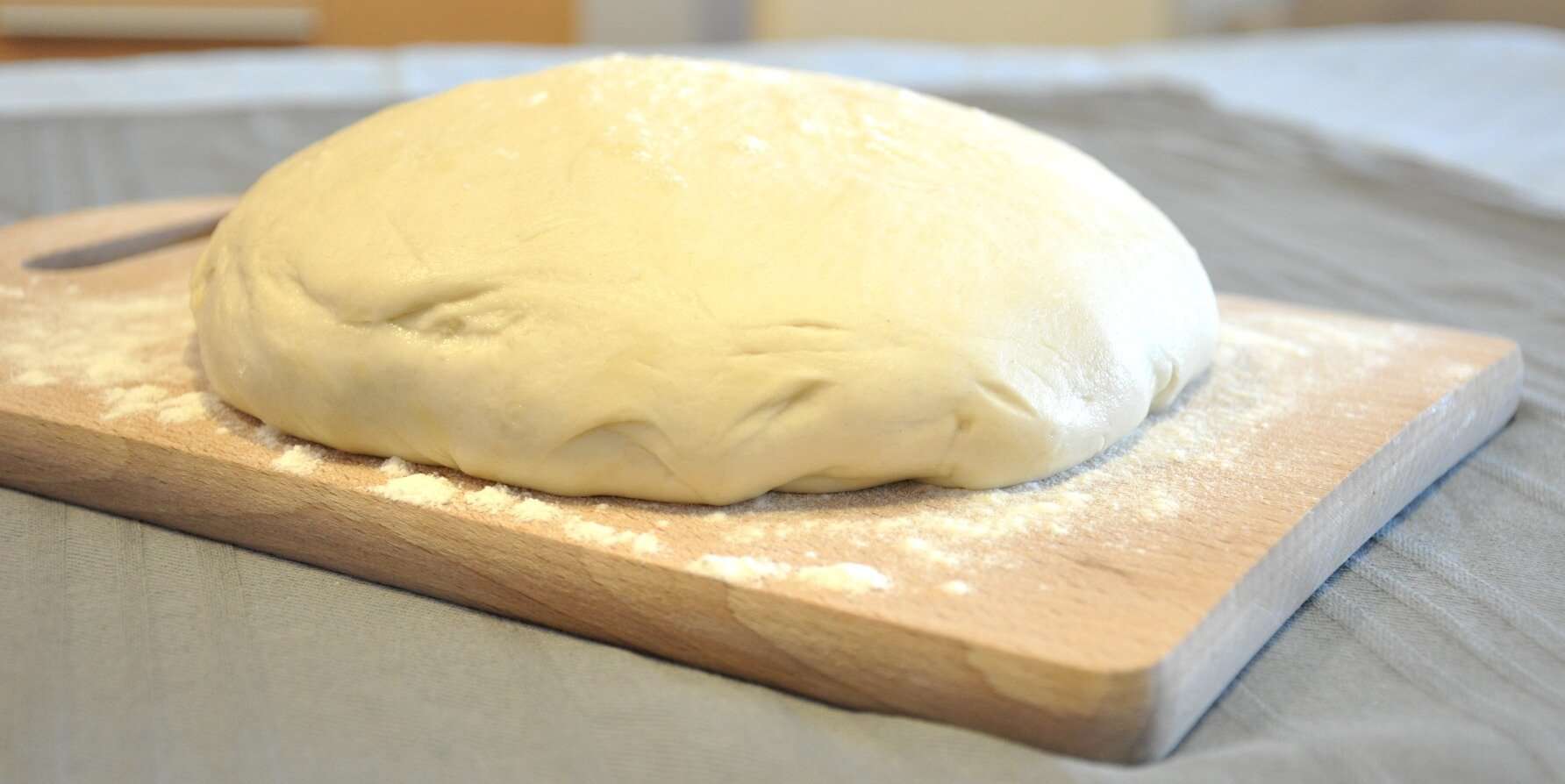 homemade pizza dough from scratch on wooden cutting board profamilychef