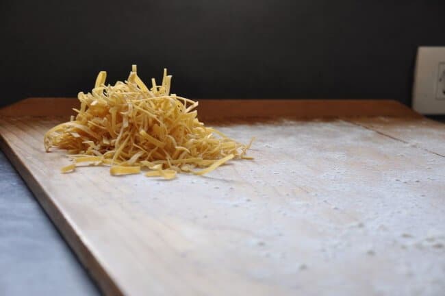 fresh noodles on wooden pasta board