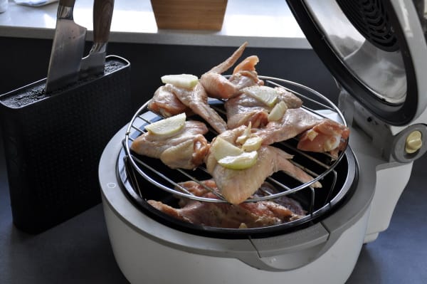 stacked chicken wings on a rack in a basket style air fryer