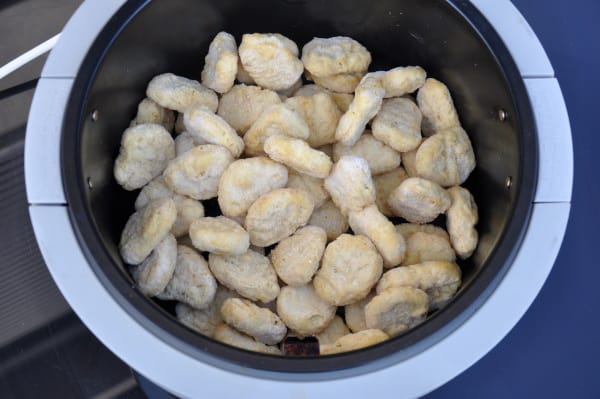 Stacked chicken nuggets in a basket style air fryer without racks