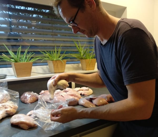 Putting cut chicken in freezer bags