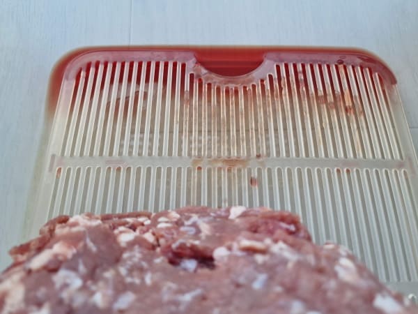 Container with draining tray for meat juices